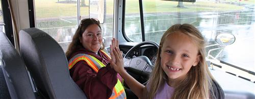 A female student high fiving a female bus driver